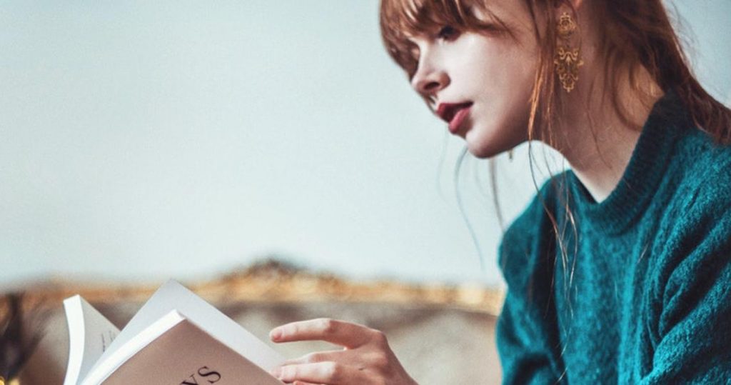 Chica leyendo un libro en sus manos