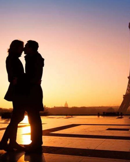 Pareja se besa frente a torre Eiffel