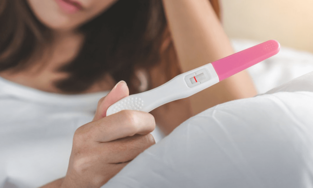 mujer con prueba de embarazo en la mano