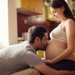 hombre besando panza de su mujer embarazada