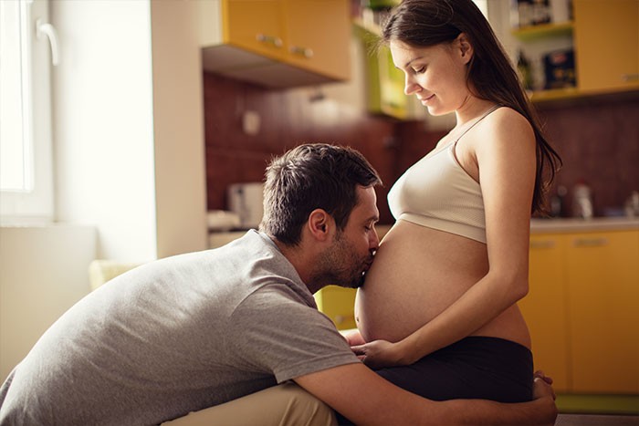 hombre besando panza de su mujer embarazada