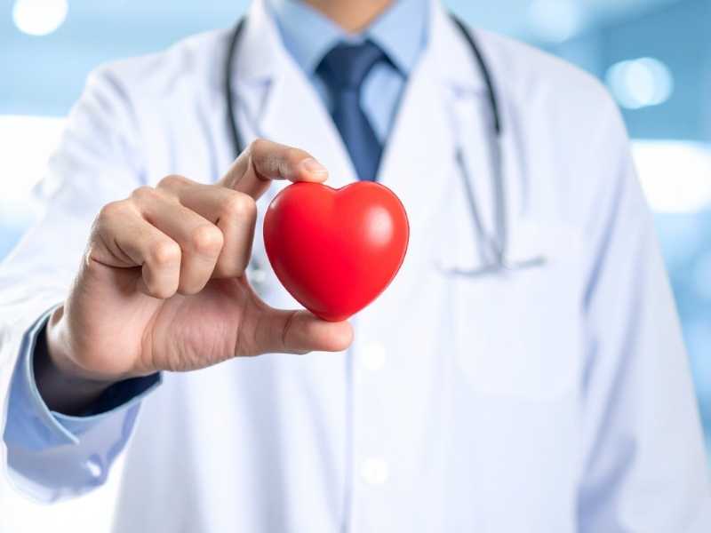 doctor con una figura de corazón entre los dedos